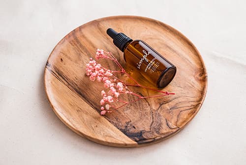 Amber dropper bottle on wooden tray mockup